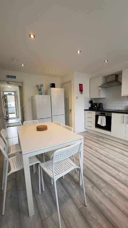 Biały stół i krzesła w kuchni w obiekcie 15 min to Central London Guest Suites 22 w Londynie