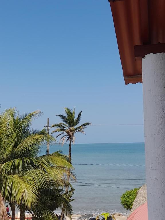 een uitzicht op een strand met palmbomen en de oceaan bij Cabaña mi negra linda in San Antero