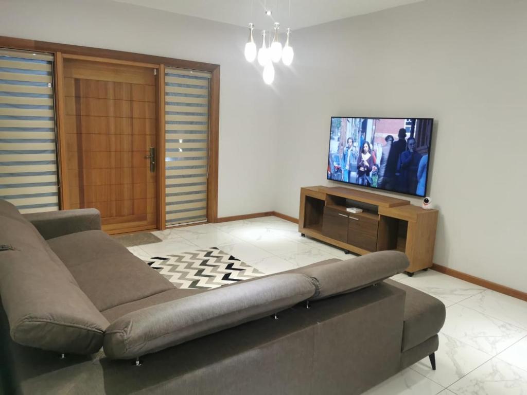 a living room with a couch and a flat screen tv at Villa d’Ebene in Ebene