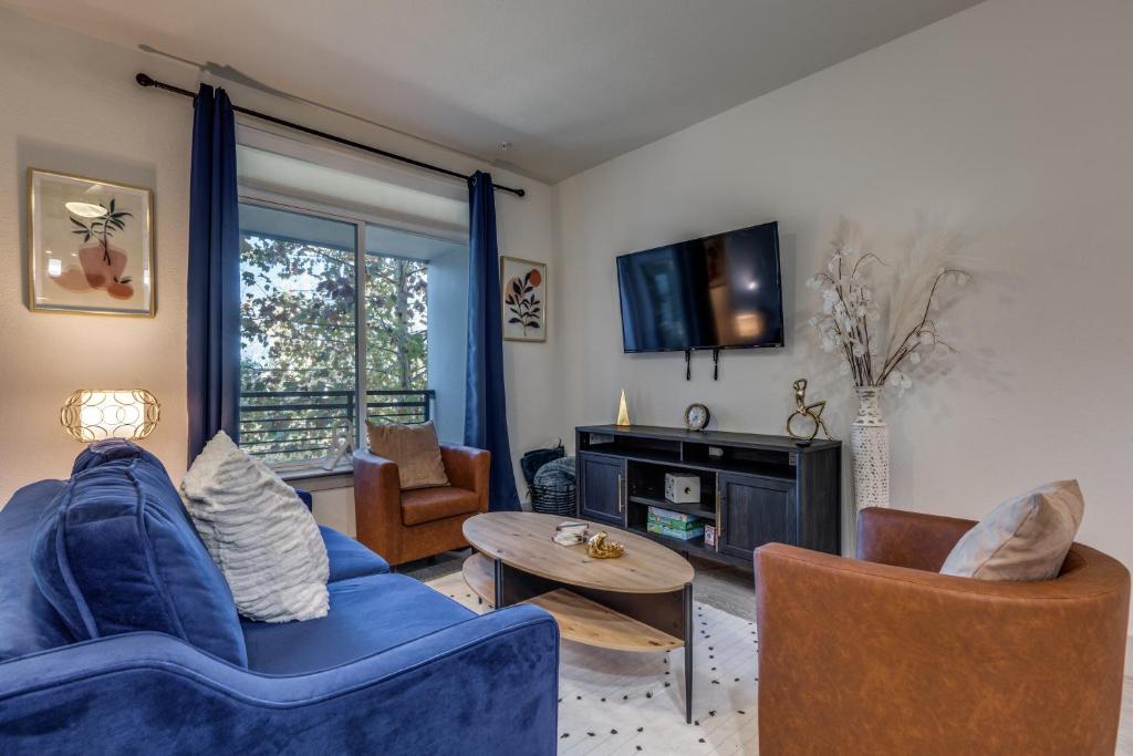 a living room with a blue couch and chairs at Gorgeous Riverwalk View Condo 1241 in San Antonio