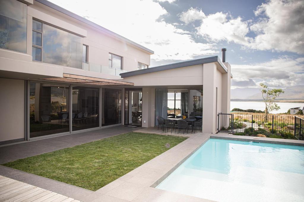 a house with a swimming pool in front of it at Milk and Honey Villa 192 in Hermanus