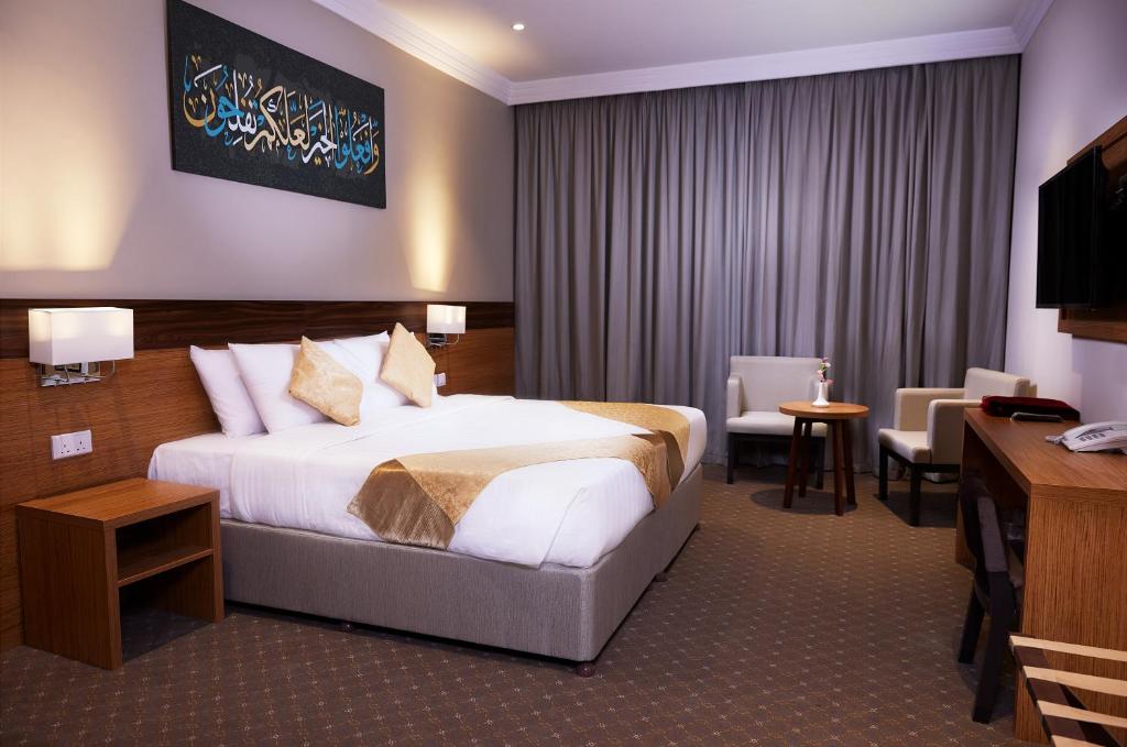 a hotel room with a bed and a desk at فندق روزن المسك مكة توصيل للحرم in Al ‘Azīzīyah