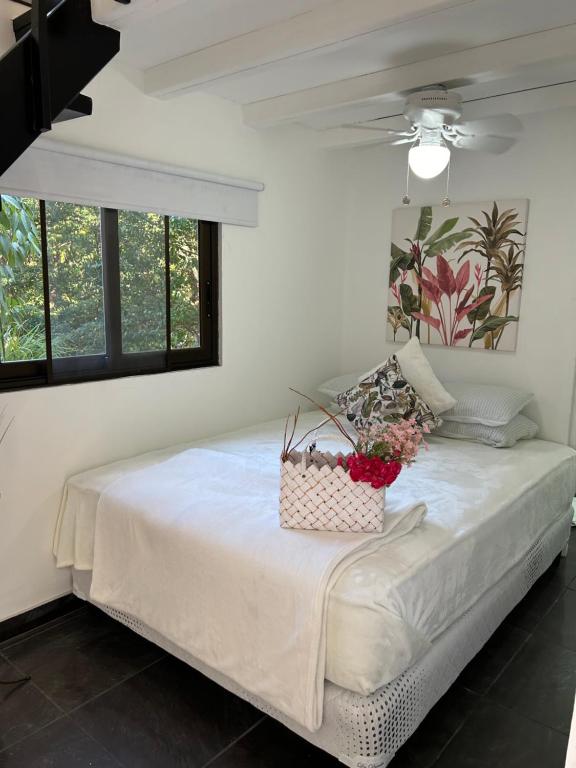 una camera da letto con un letto e un cesto di fiori di Apartment with loft in Altos del Maria a Sorá