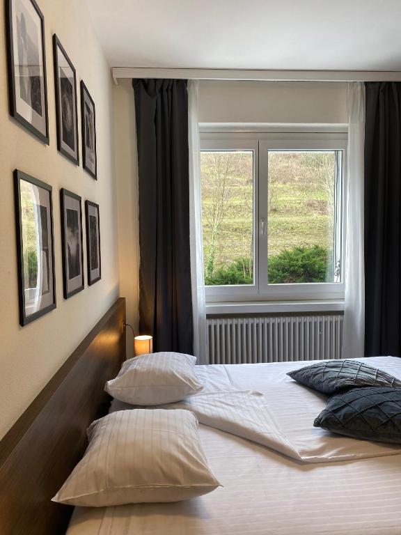 una camera da letto con letto, cuscini e finestra di Hotel Locanda dei Mulini a Novazzano