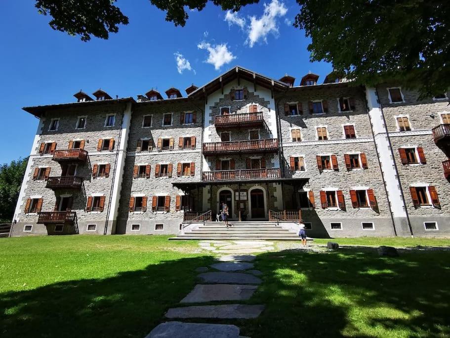 a large building with people standing in front of it at Appartamento del Re e della Regina in Ceresole Reale