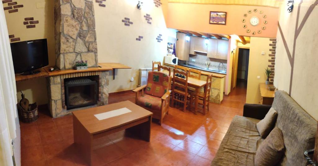 un salon avec un canapé et une cheminée dans l'établissement CASA RURAL LA SERROTA, à San Martín de la Vega del Alberche