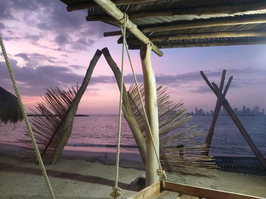 a swing on the beach with a view of the ocean at Island-style lodging & beach club in Tierra Bomba