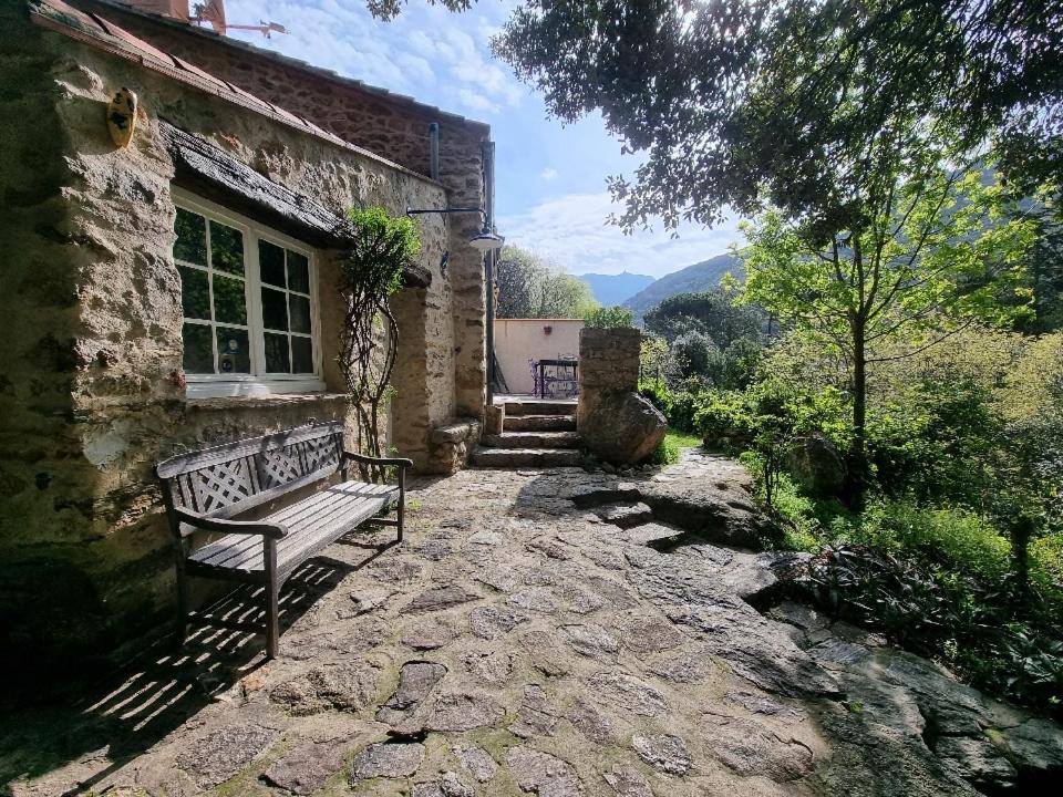 a bench sitting outside of a stone building at la bergerie in Sorède