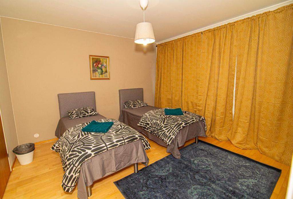 2 camas individuais num quarto com uma janela em 2-Bedroom Apartment in Heart of City Center em Turku