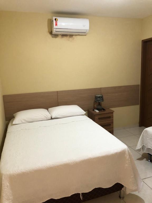 a bedroom with a bed and a air conditioner on the wall at Casa Costa do Mar - Pé na areia em Maragogi in Maragogi