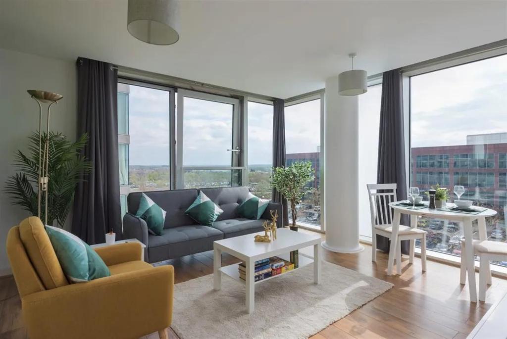 a living room with a couch and a table at Luxury Milton Keynes Apartment at The Prevé in Milton Keynes