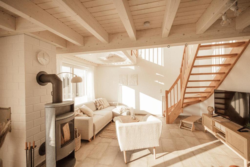 ein Wohnzimmer mit einem Sofa und einem Holzofen in der Unterkunft Traumhafte Seelodge mit Sauna, Kamin und Whirlpool in Nordhorn