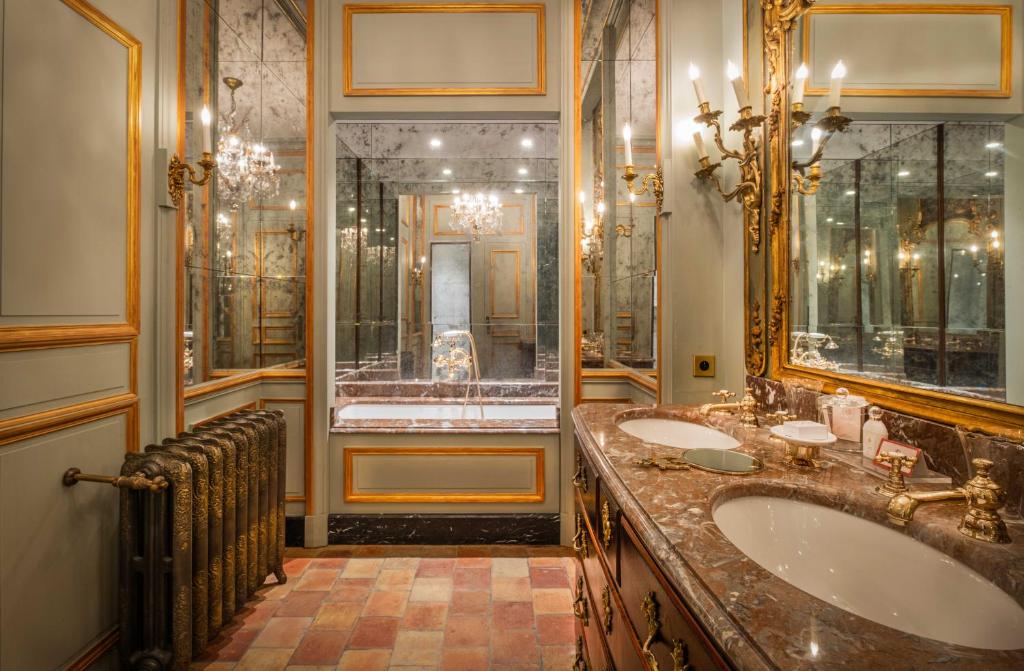 een badkamer met 2 wastafels en een douche bij Relais & Château Louise de La Vallière in Reugny