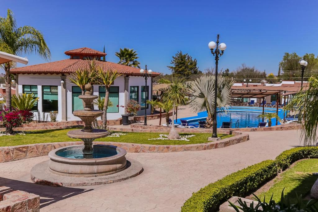 una fuente frente a un complejo con piscina en Hotel Real de San Jose en Tequisquiapan