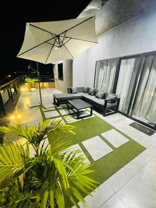 a living room with a couch and an umbrella at Serenity Haven:Your Ideal Escape in Lomé