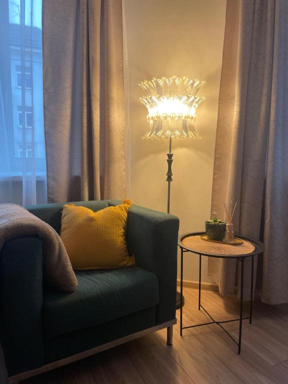 sala de estar con sofá azul y lámpara en Värskelt renoveeritud hubane korter Tartus, en Tartu