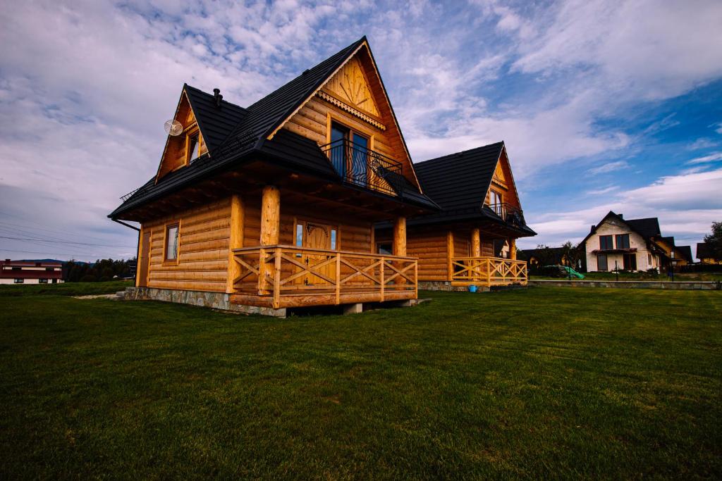 a large wooden house on a grass field at Sielanka u Stanka in Szaflary