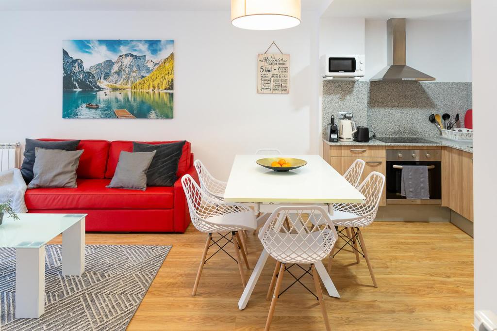 a living room with a red couch and a table at AndBnB I Apartamento con Terraza y Parking in Arinsal