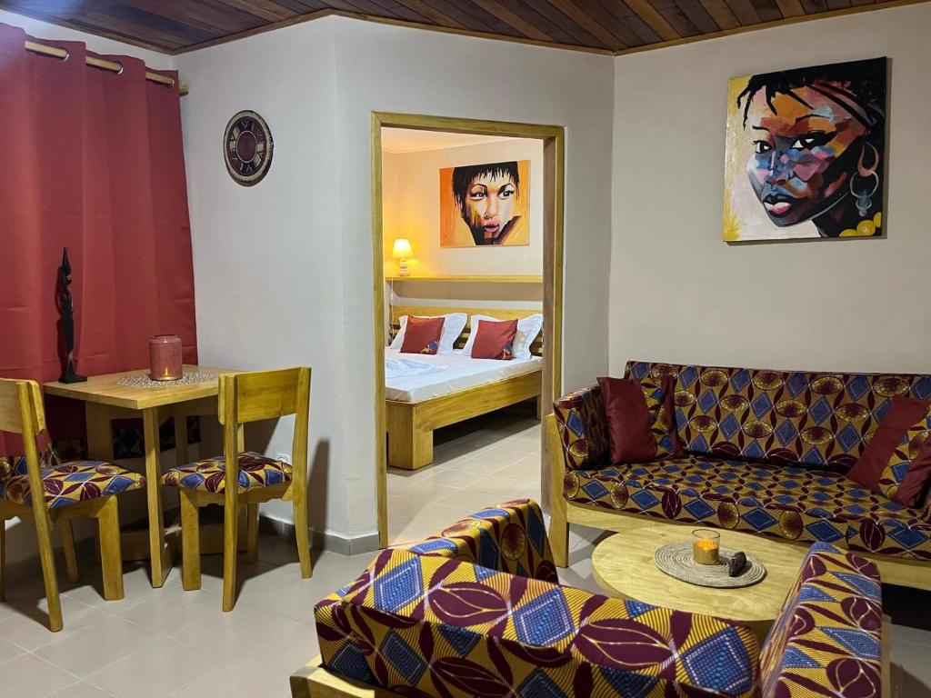 a living room with a couch and a bedroom at RKS - Résidence Kribi Soleil in Kribi