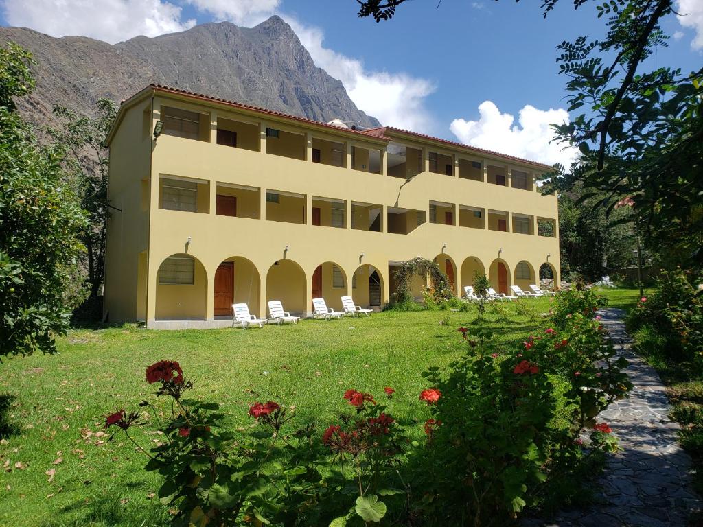 a large building with chairs and flowers in front of it at Condominio La Curva in Churín