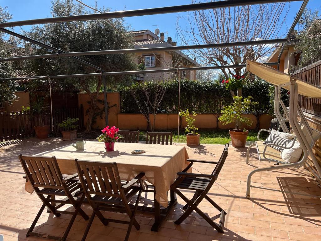 un patio con una mesa con 4 sillas en Garden House Ciampino, en Ciampino