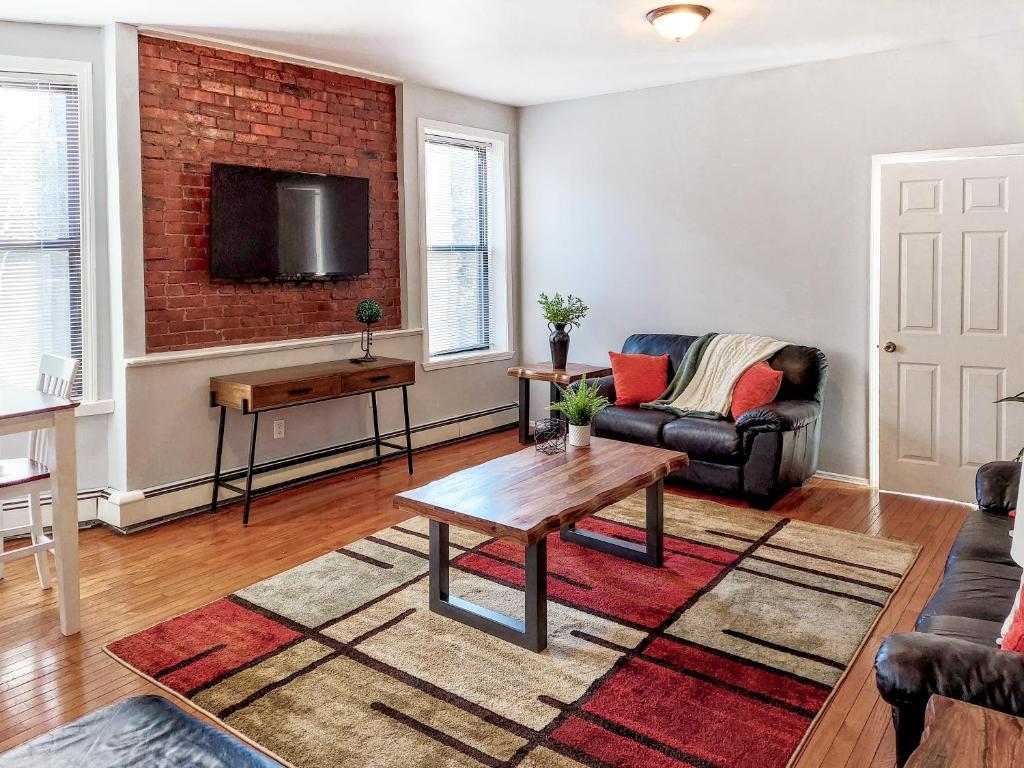 ein Wohnzimmer mit einem Sofa und einem Tisch in der Unterkunft Spacious Getaway by Wooster Square! in New Haven