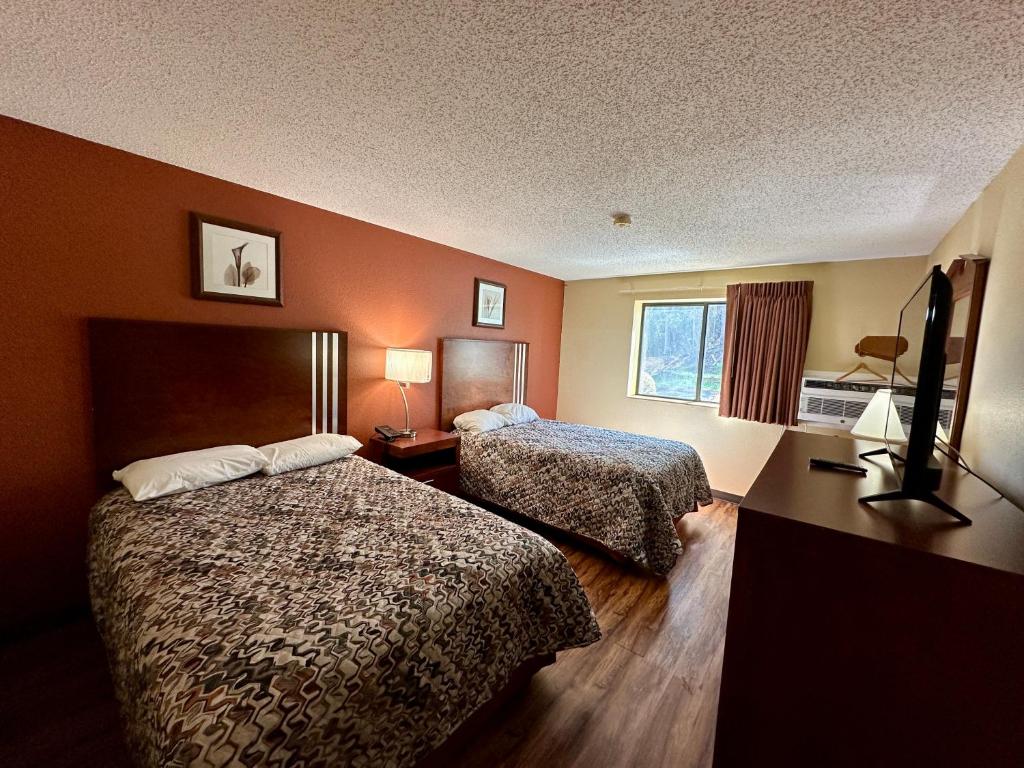 a hotel room with two beds and a window at American Inn-Alexander City in Alexander City