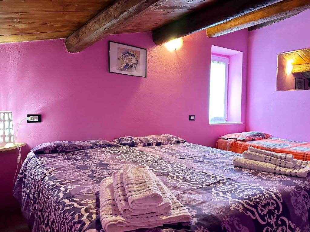 1 dormitorio con paredes moradas y 1 cama grande en Al Vecchio Mulino da Nonna Ninetta, en Corfinio