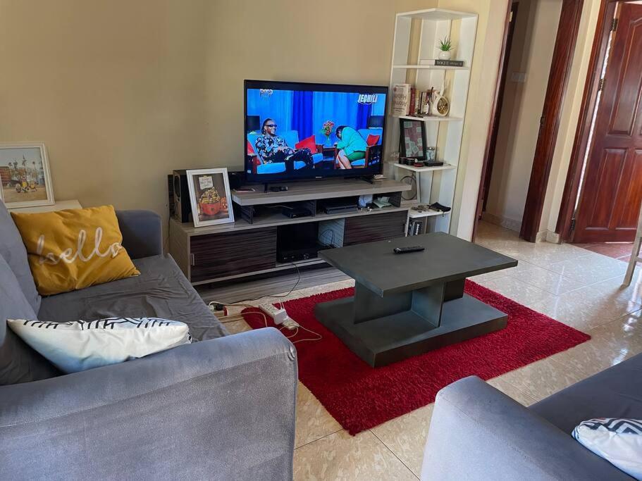 a living room with a couch and a tv at Calm Haven: Your Private Retreat in Kira