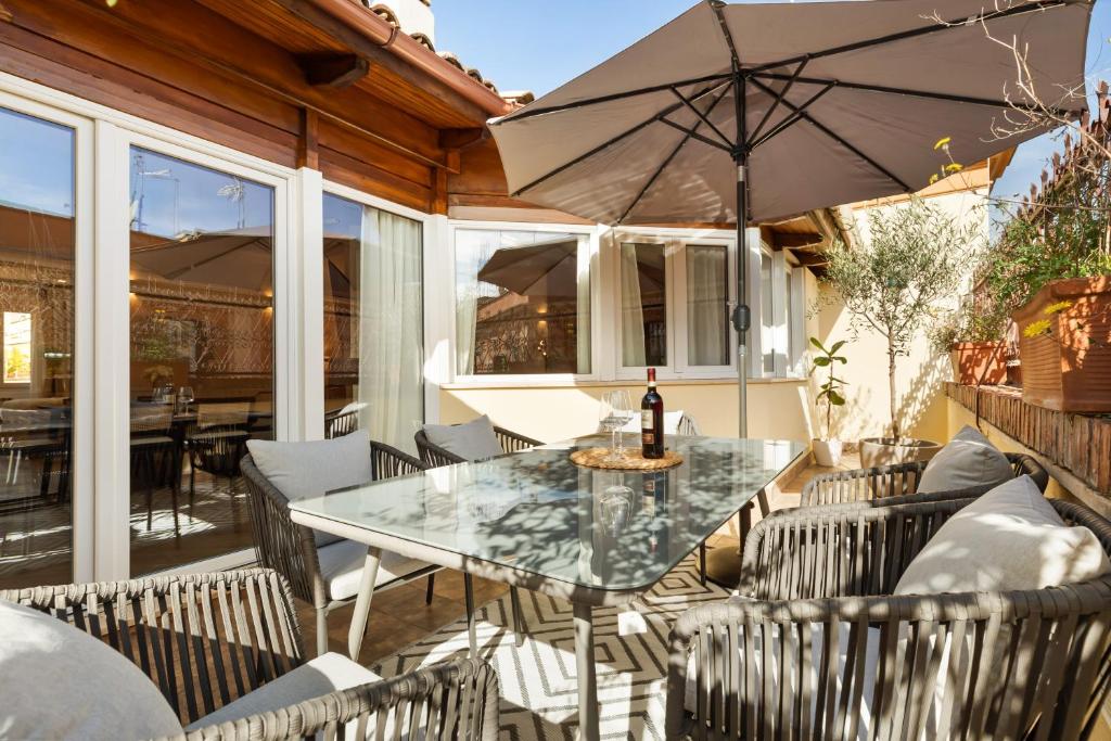 Hotel Terrace Boutique Apartment - Dolce Vita, a patio with a table and chairs and an umbrella at Terrace Boutique Apartment - Dolce Vita in Rome