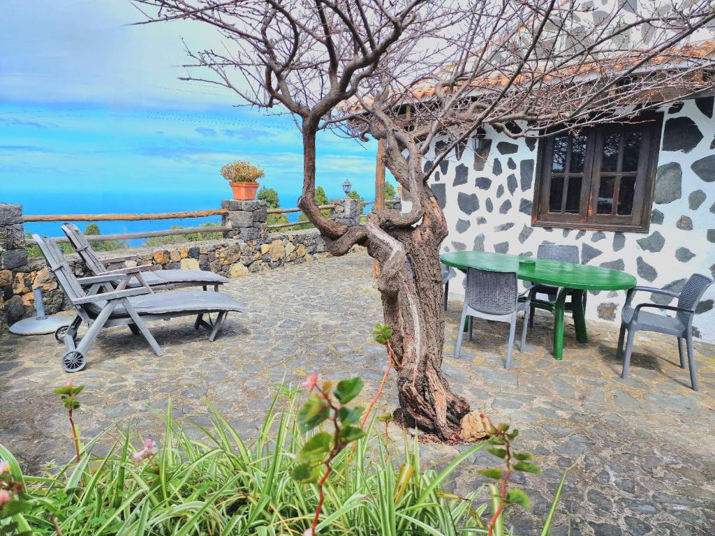 Un patio con una mesa y sillas al lado de un edificio. en Casa Canaria Drago in Icod de los Vinos, en Icod de los Vinos