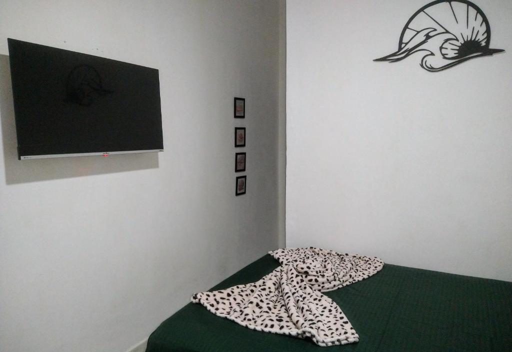 Un dormitorio con una cama con una manta. en Pousada Primeira Quadra Da Praia en Praia Grande