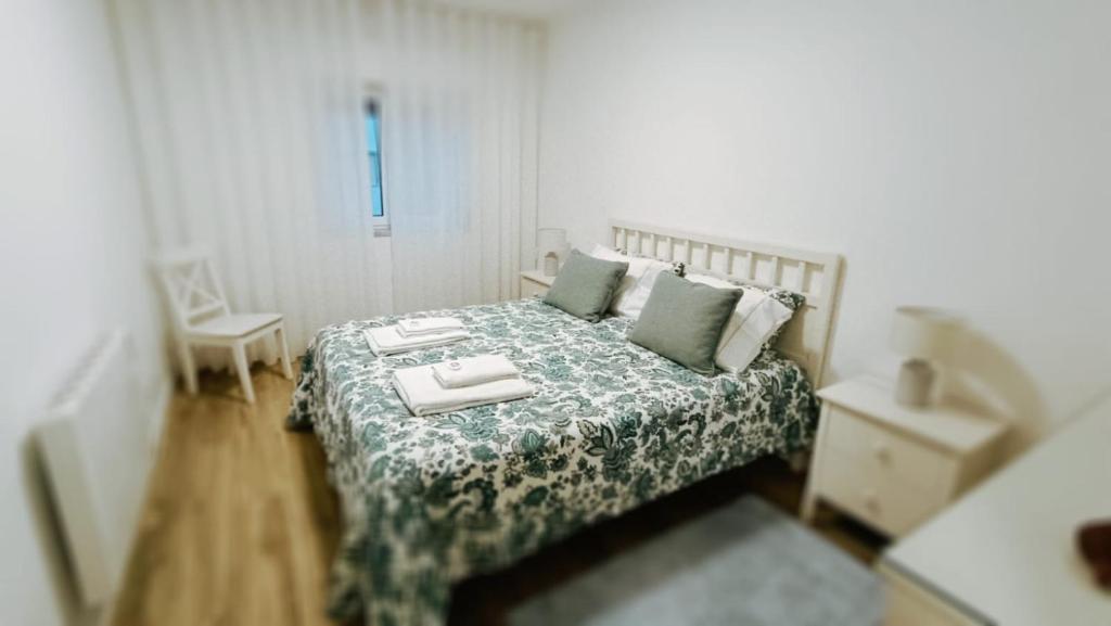 een slaapkamer met een bed met een groene en witte sprei bij Peniche's Blue & Yellow in Peniche