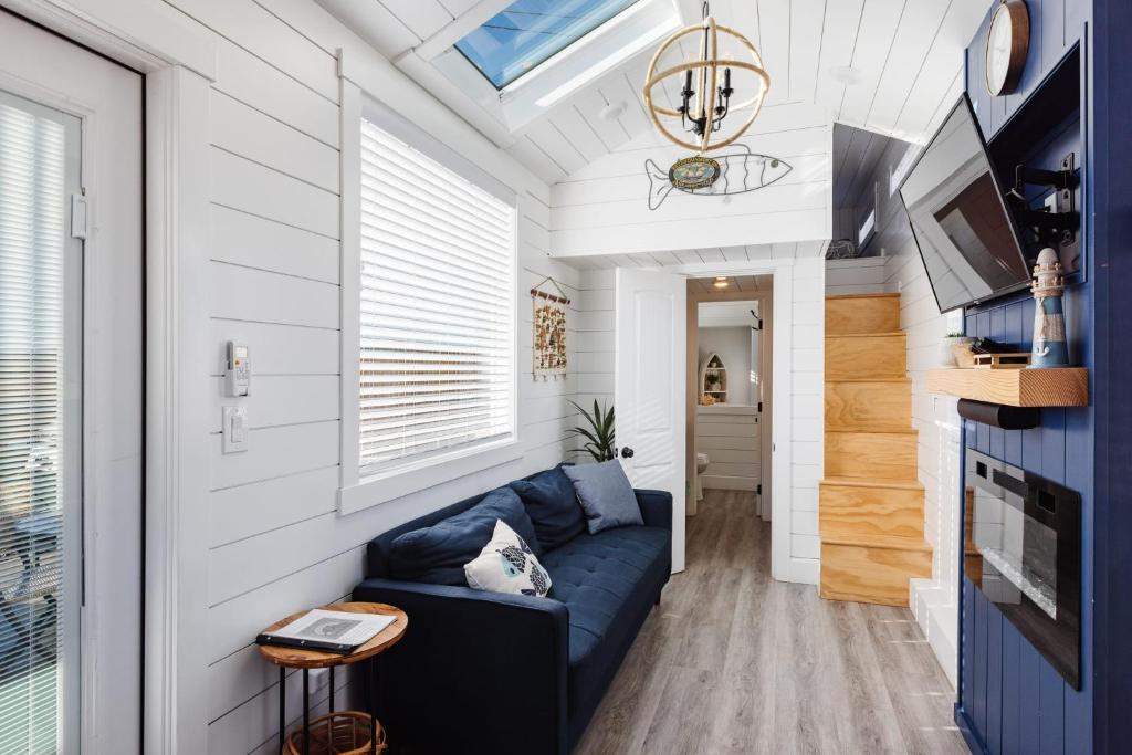 a living room with a blue couch in a tiny house at Zion Stay, Scenic Tiny Home & Sunset Views in Apple Valley