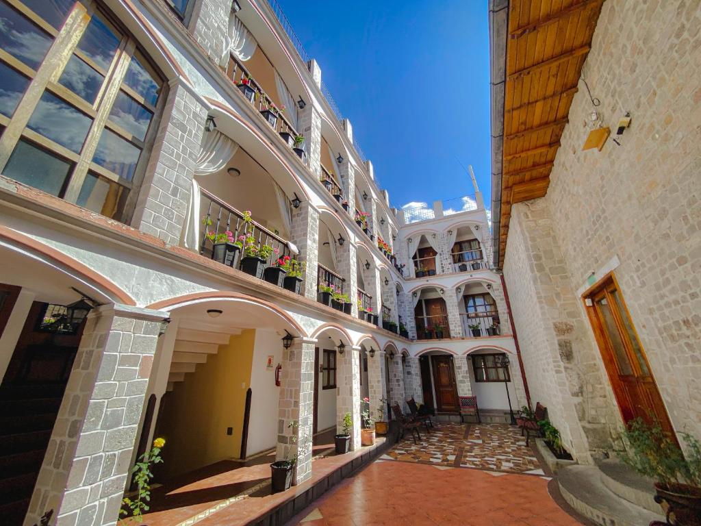 an alleyway in an old building with balconies at Golden Rest Ecuador in Latacunga