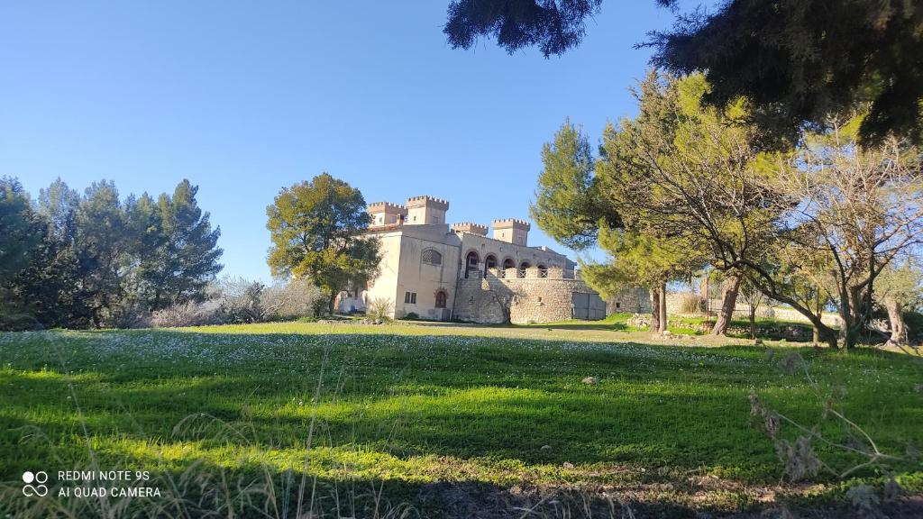 an old castle on a grassy field with trees at Casa vacanze nel cuore della sicilia in Santa Caterina Villarmosa