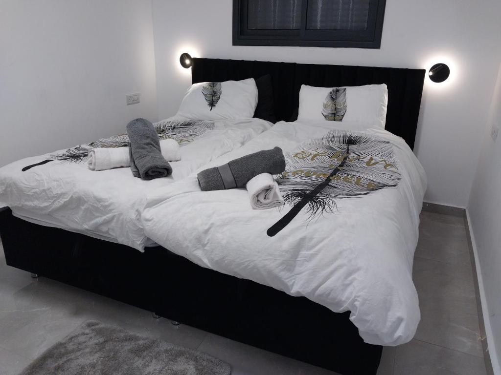 duże łóżko z białą pościelą i poduszkami w obiekcie שירת דבורה בבני ברק w mieście Giv‘at Shemuʼel