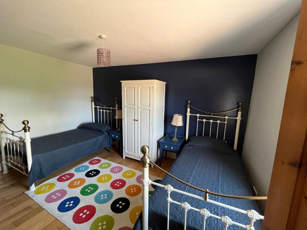 1 dormitorio con 2 camas y alfombra en Reenard South seaview country cottage, en Cahersiveen