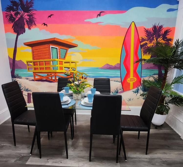 une table avec des chaises et une peinture murale d'une planche de surf dans l'établissement Beach Oasis, Mins to CP & SF, King/WD/Pet OK, à Sandusky
