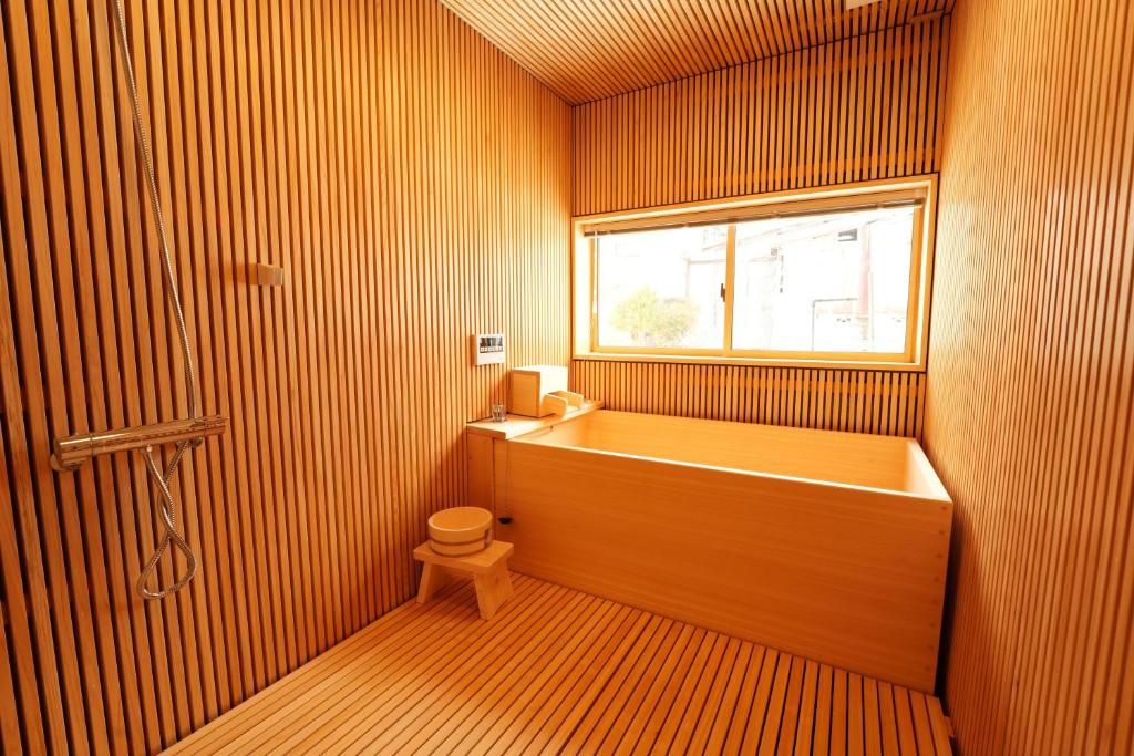 łazienka z wanną, toaletą i oknem w obiekcie RIKKA BABA NI w mieście Takayama
