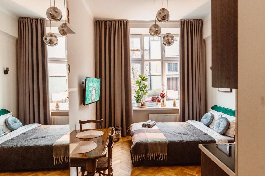 a hotel room with two beds and a table at Apartament na Krakowskim Kazimierzu in Krakow