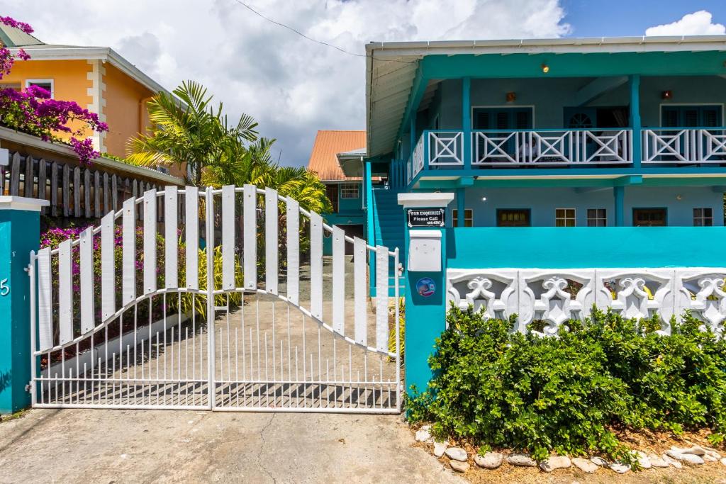 une porte blanche devant une maison bleue dans l'établissement Beach House In Crown Point- walk to the beach, à Bon Accord