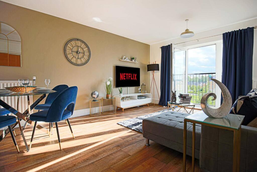 uma sala de estar com uma mesa e cadeiras azuis em Luxury Apartment with Balcony, Fast WIFI, Smart TVs and Free Parking by Yoko Property em Milton Keynes