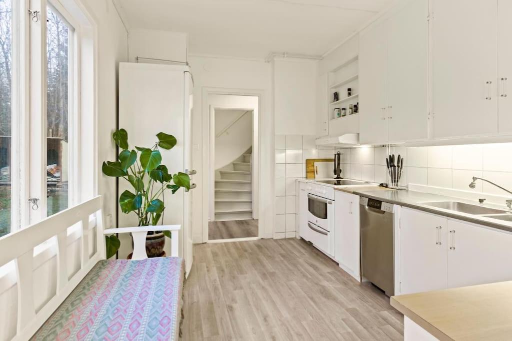 a kitchen with white cabinets and a potted plant at Comfy 4-bedroom barnhouse Ideal for Long Stays in Åkersberga