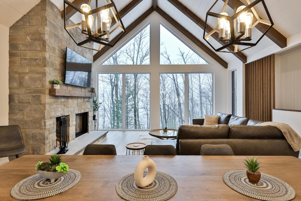 a living room with a table and a fireplace at The Chic Shack - Golf, Ski, SPA in Saint-Faustin