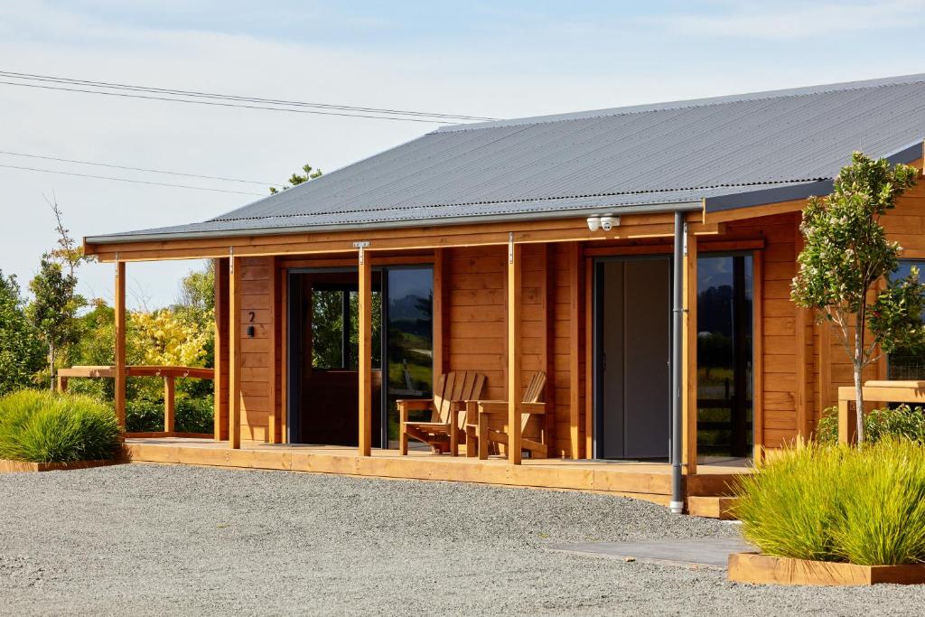 une cabane en bois avec une table et des chaises dans l'établissement Deerbrooke Kaikōura Chalets - Chalet 2, à Kaikoura