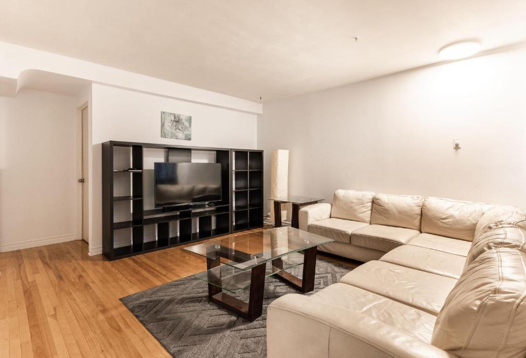 sala de estar con sofá y TV en Grand appartement 4 chambres - 335, en Montreal