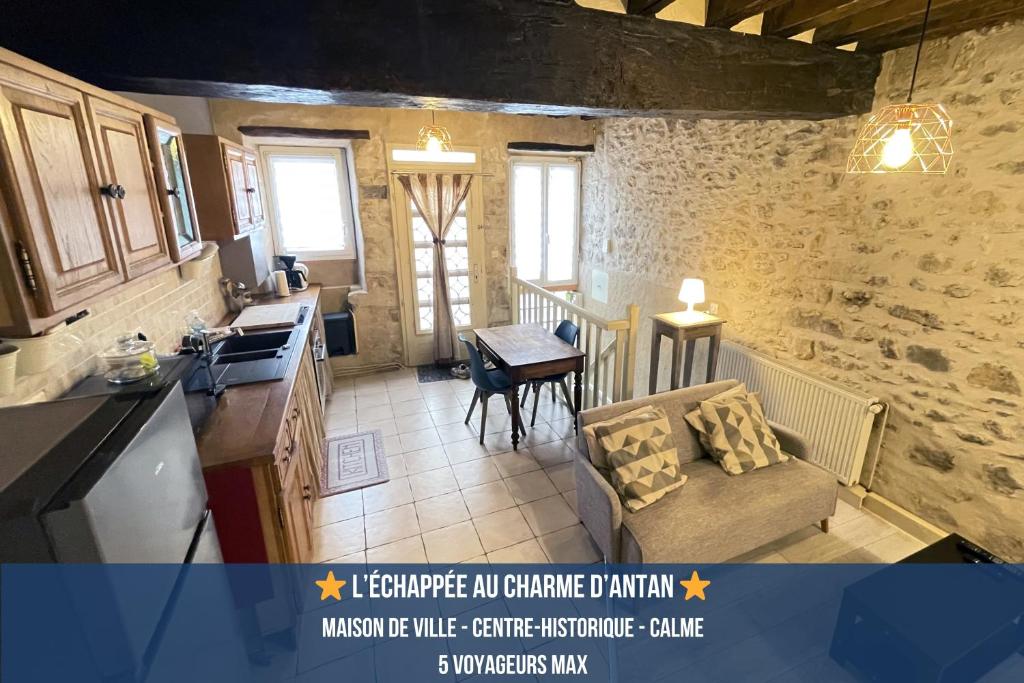 a kitchen with a couch and a table in a room at Escapade Moretaine - L'Echappée au charme d'antan in Moret-sur-Loing