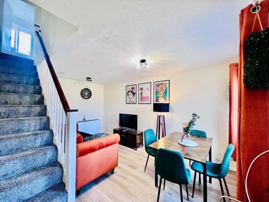a living room with a staircase and a table and chairs at Brand New! The Cosy Cove by Artisan Stays I Long Weekend Offer I Free Parking in Chelmsford