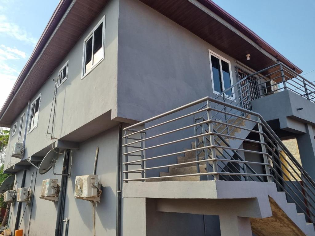 a house with a staircase on the side of it at Cozy Escape in Accra by Manna Hospital in Accra